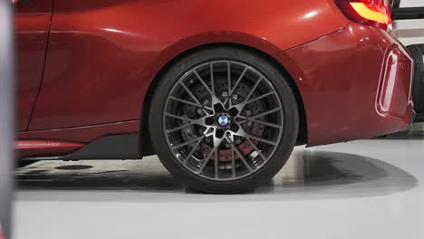 bmw m2 luxury car expansive wheel, tire and body closeup, bmw in reverse gear