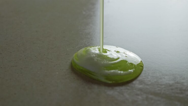 Pouring Sticky Green Fluid With White Foam On Shiny Surface