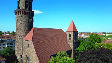 Beautiful-aerial-top-view-flight-Lukas-church-city-Berlin-steglitz,-Germany-Summer-day-2023