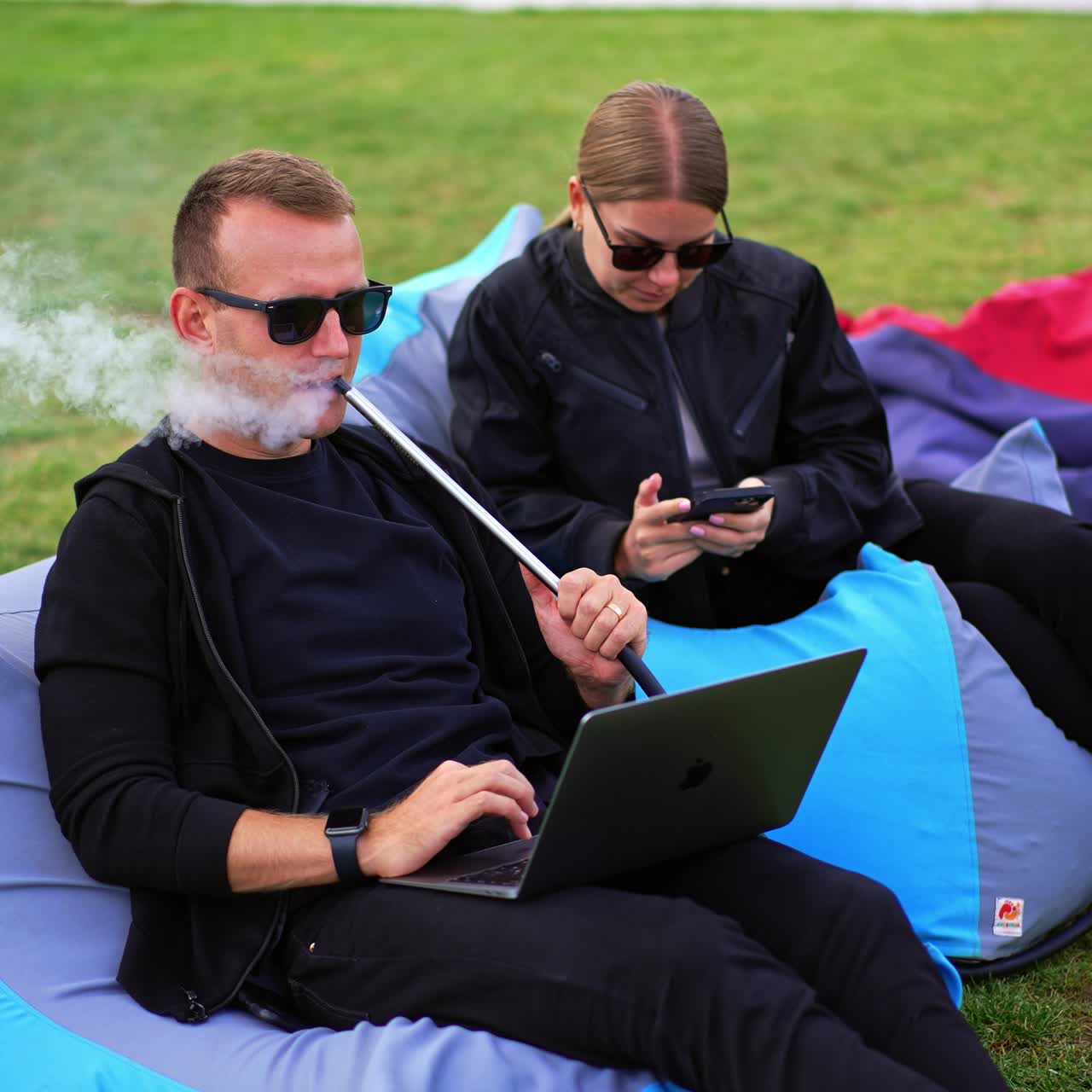 Young couple relaxing together. Outdoor having fun with hookah