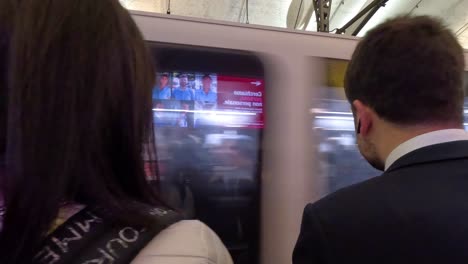 dos personas esperando a que llegue el metro.