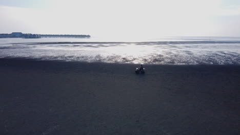 atv driving along the waterfront in bagan lalang on a foggy morning, malaysia