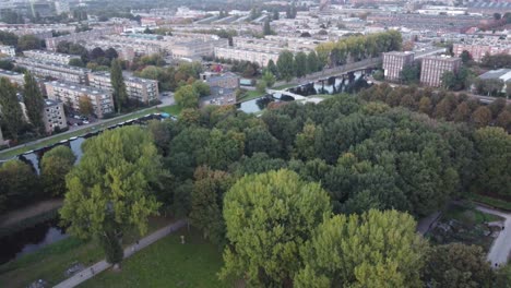 aerial view of amsterdam, the netherlands, it is getting closer you can see the canals and the architecture of its typical houses and a very leafy green park