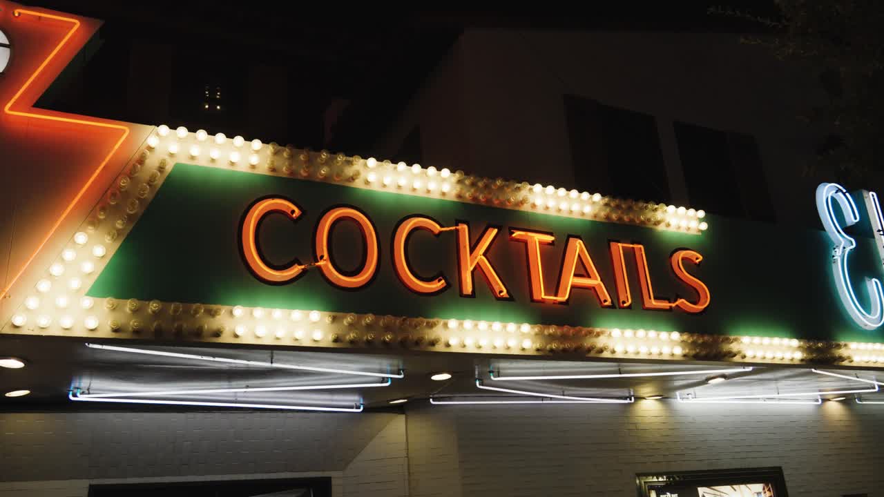 A green and gold sign reads &amp;quot;Cocktails&amp;quot; using neon lights in a flickering pattern and red neon tube letters in the old town Fremont district of Las Vegas