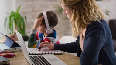 handheld video of mother working while son is home schooling