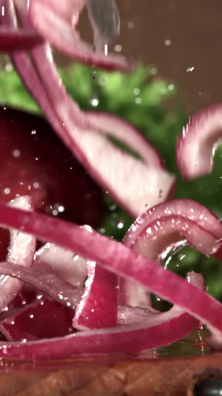 Slow Motion of Red Onion Slices Falling and Splashing with Water