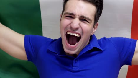 italian young man celebrates holding the flag of italy in slow motion