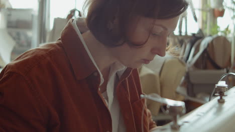 female shoemaker using sewing machine at work