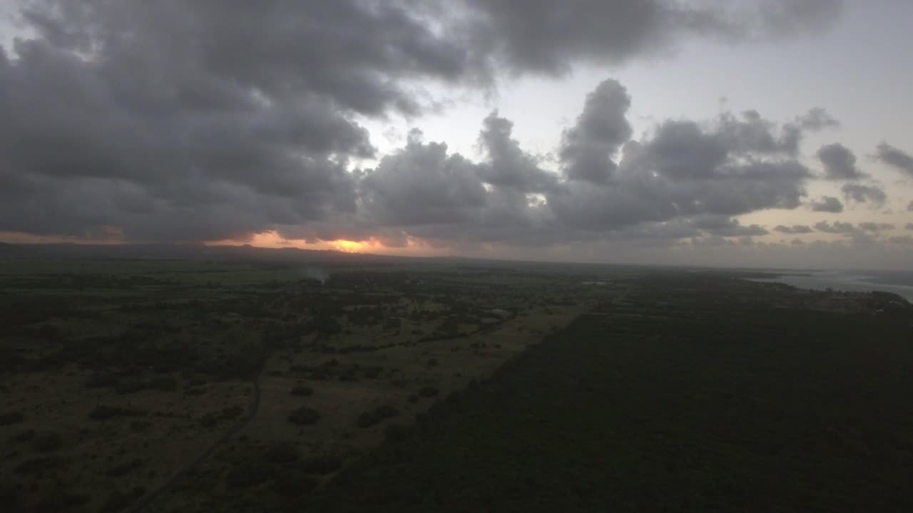 Vista aerea delle foreste, dei campi agricoli e delle colline dell'Isola di Mauritius contro il cielo al tramonto e nuvole rosa