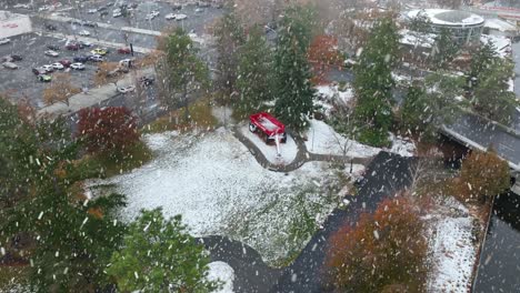 aerial view of snow actively falling on the big red wagon at spokane's waterfront park