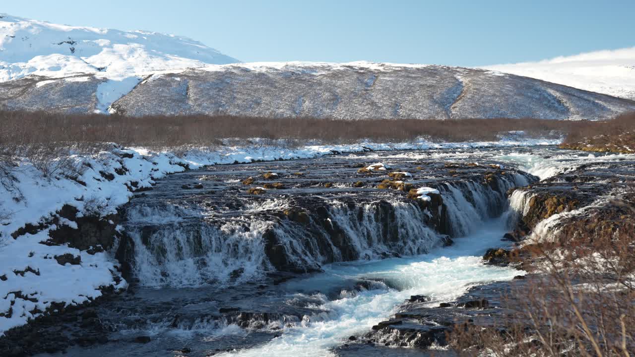 Brúarfoss waterfall cascading through icy river in Laugarvatn Iceland