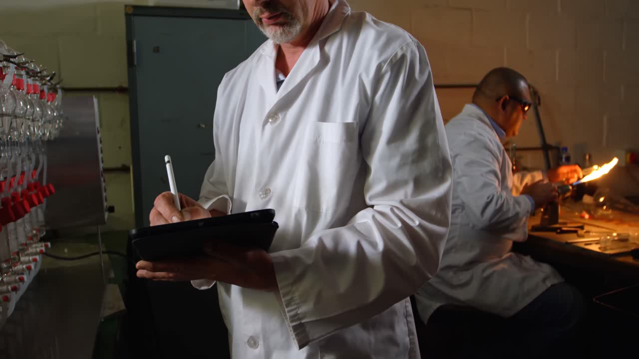 유리 공장에서 그래픽 태블릿을 사용하는 남성 노동자의 중간 섹션 4k