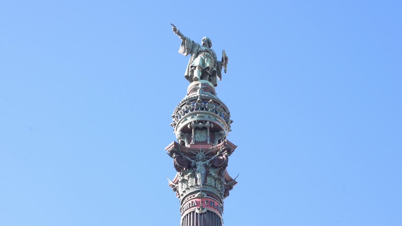 Looking up at the iconic Columbus Monument in Barcelona, Spain. The bronze statue of Christopher Columbus (Cristóbal Colón) points out towards the sea, symbolizing his voyage to the Americas