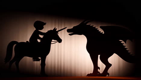 shadow puppet show: boy on unicorn vs. dragon