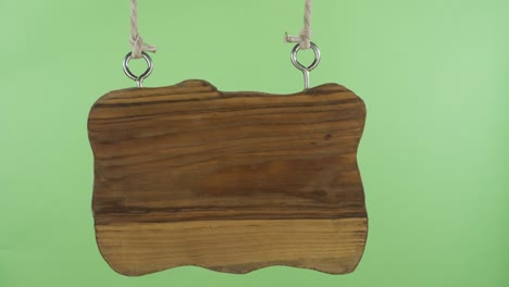 an old empty wooden sign sways to the sides. green screen