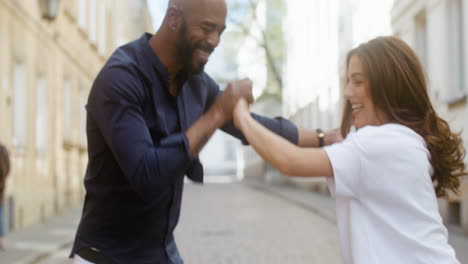 close up of a happy interracial couple dancing bachata in the old town street