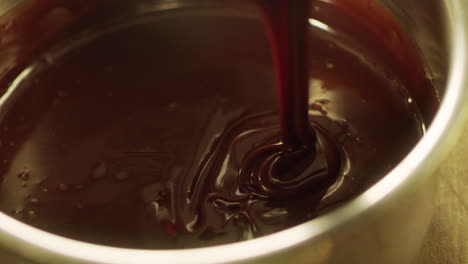 mixing chocolate with whisk in slow motion. closeup liquid hot chocolate.