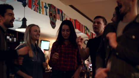 jóvenes felices con ropa casual están bailando en un bar moderno. están riendo y charlando, divirtiéndose juntos. millennials disfrutando del concepto de la vida nocturna.