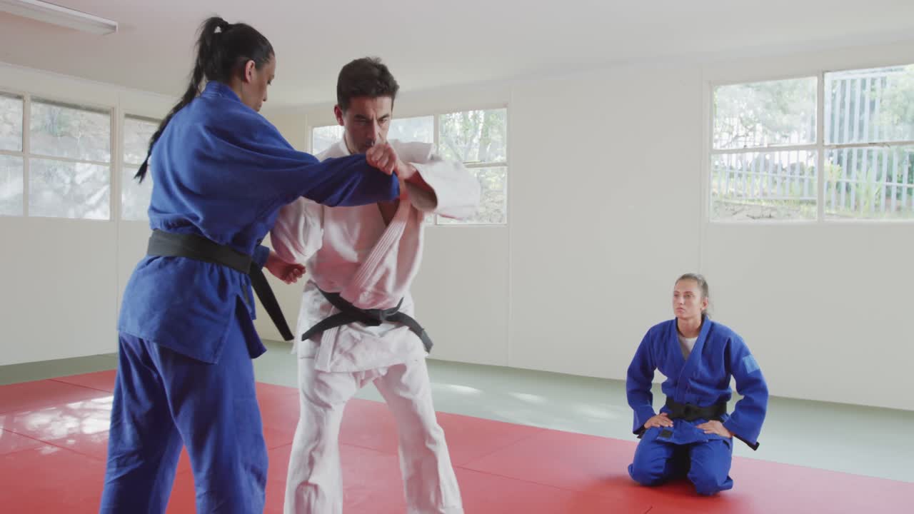 los judokas entrenan mientras otro está mirando
