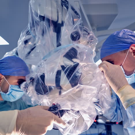 operation through microscope. two doctors looking into the contemporary microscope during the operation. modern equipment in the operating room.
