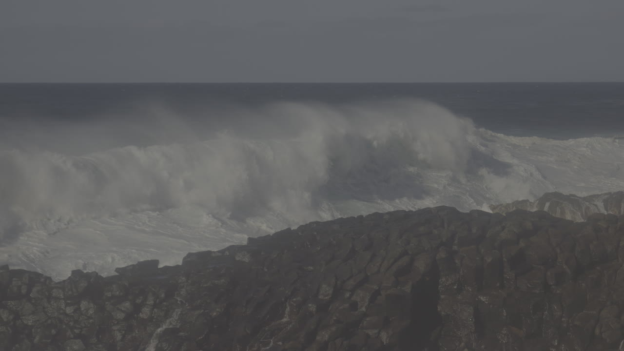 강력한 파도가 바위가 있는 해안선에 부히고