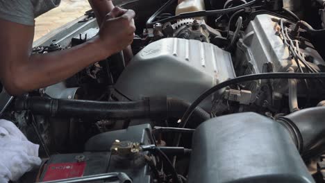 close shot of a mechanic fixing a car engine