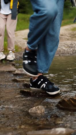 people hiking over a stream