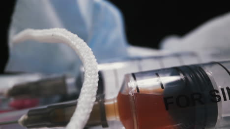 syringe with vaccine and different drugs on black background