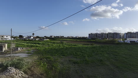 dron volando bajo cables eléctricos y sobre un campo