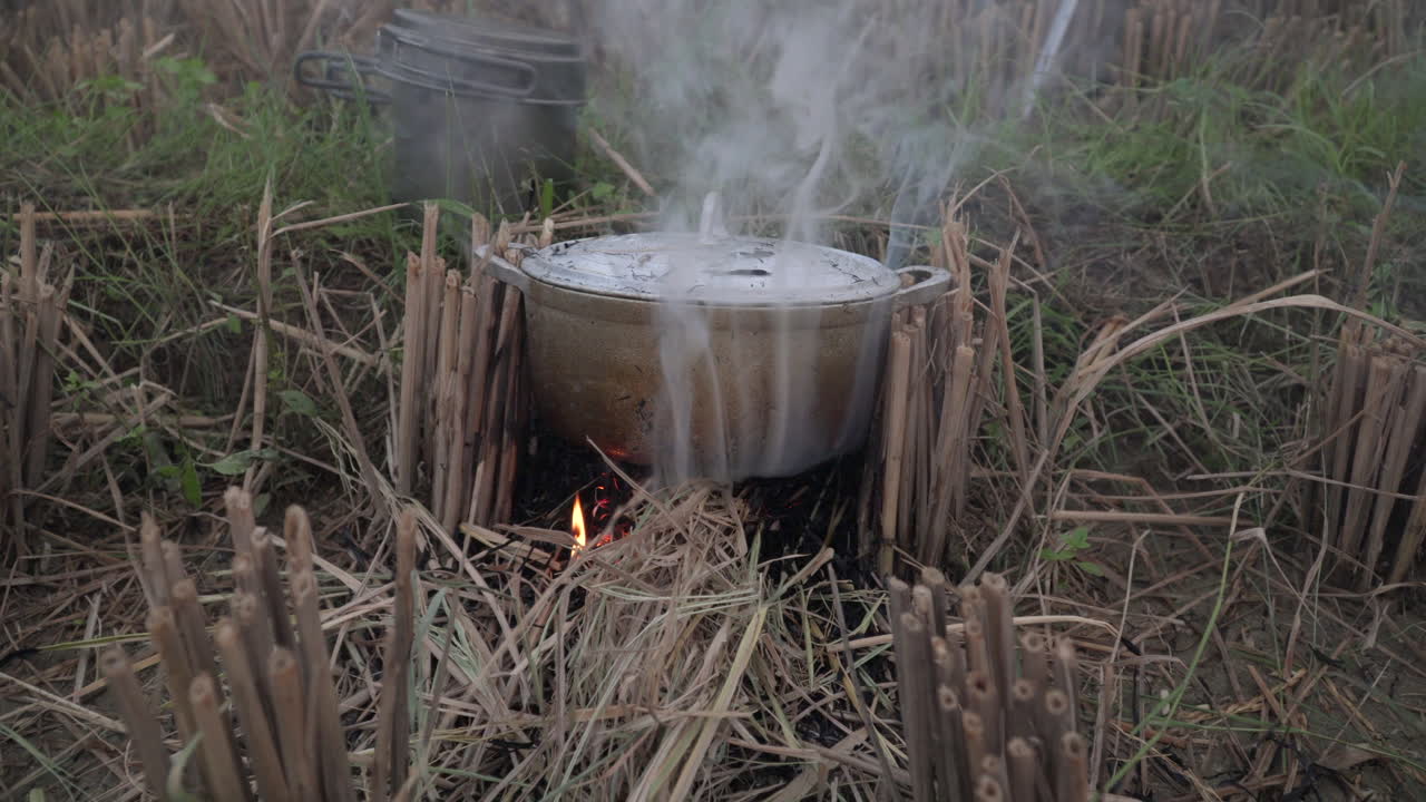 Cooking outdoors over a campfire in a rural field