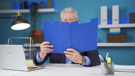 cheerful businessman working on files.