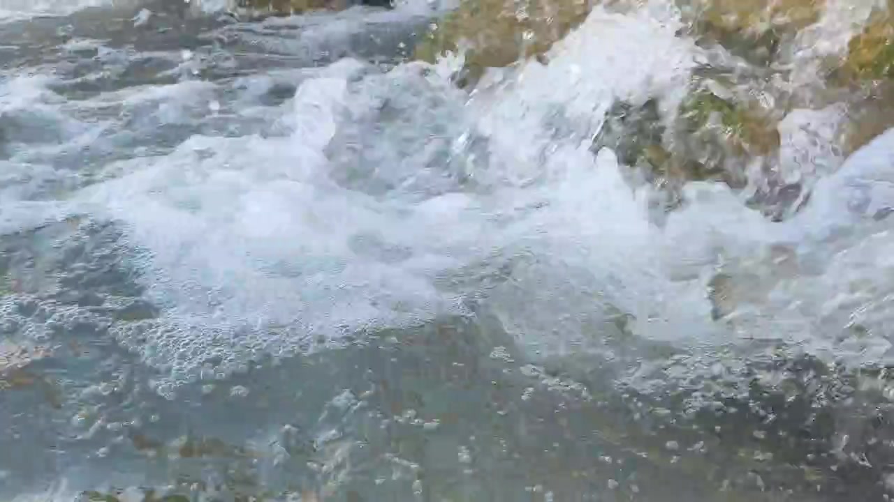 Acqua cristallina che scorre sulle rocce in un ruscello naturale.