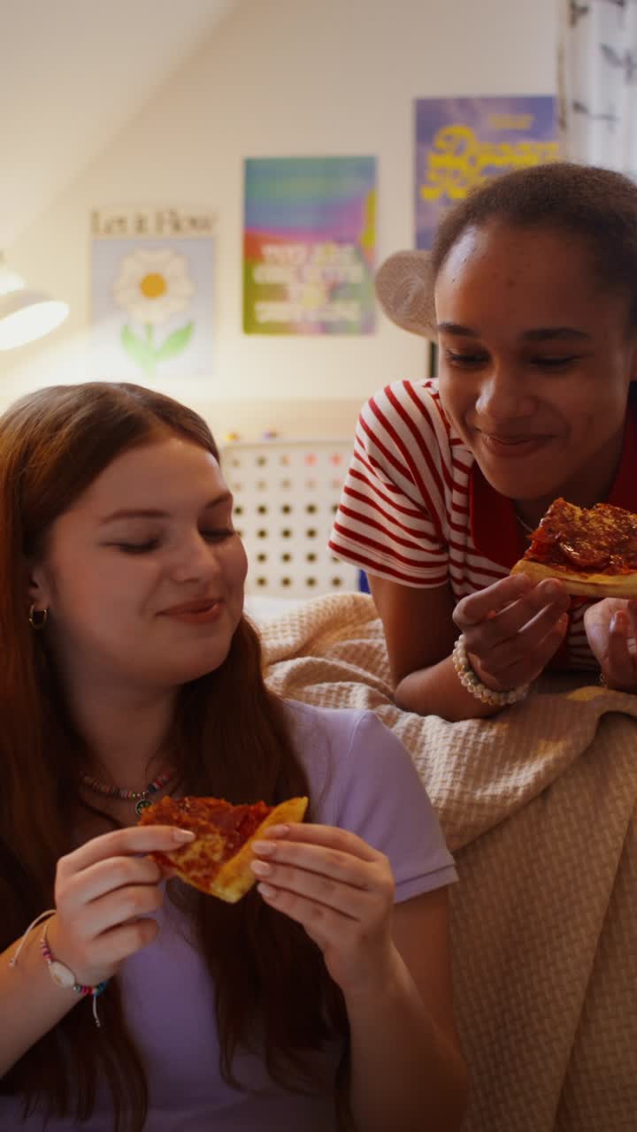 chicas adolescentes comiendo pizza en el dormitorio