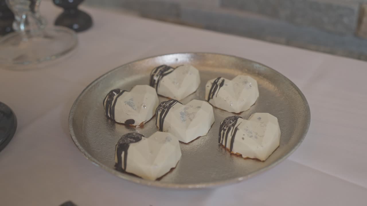 Sweets from the sweetbar in the form of hearts with chocolate. Professionally decorated candy at a wedding reception