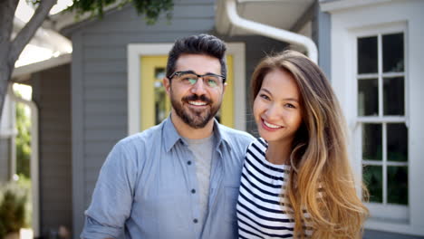 Portrait-Of-Young-Couple-Standing-Outside-New-Home