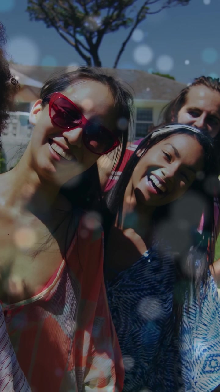 Video verticale: Amici che si sporgono verso la telecamera, un suggerimento fuori campo li fa assumere una posa di marketing con una sovrapposizione bokeh.