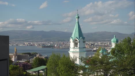 turquoise roof of the russian orthodox church in motomachi with hakodate bay in the background japan on a sunny day