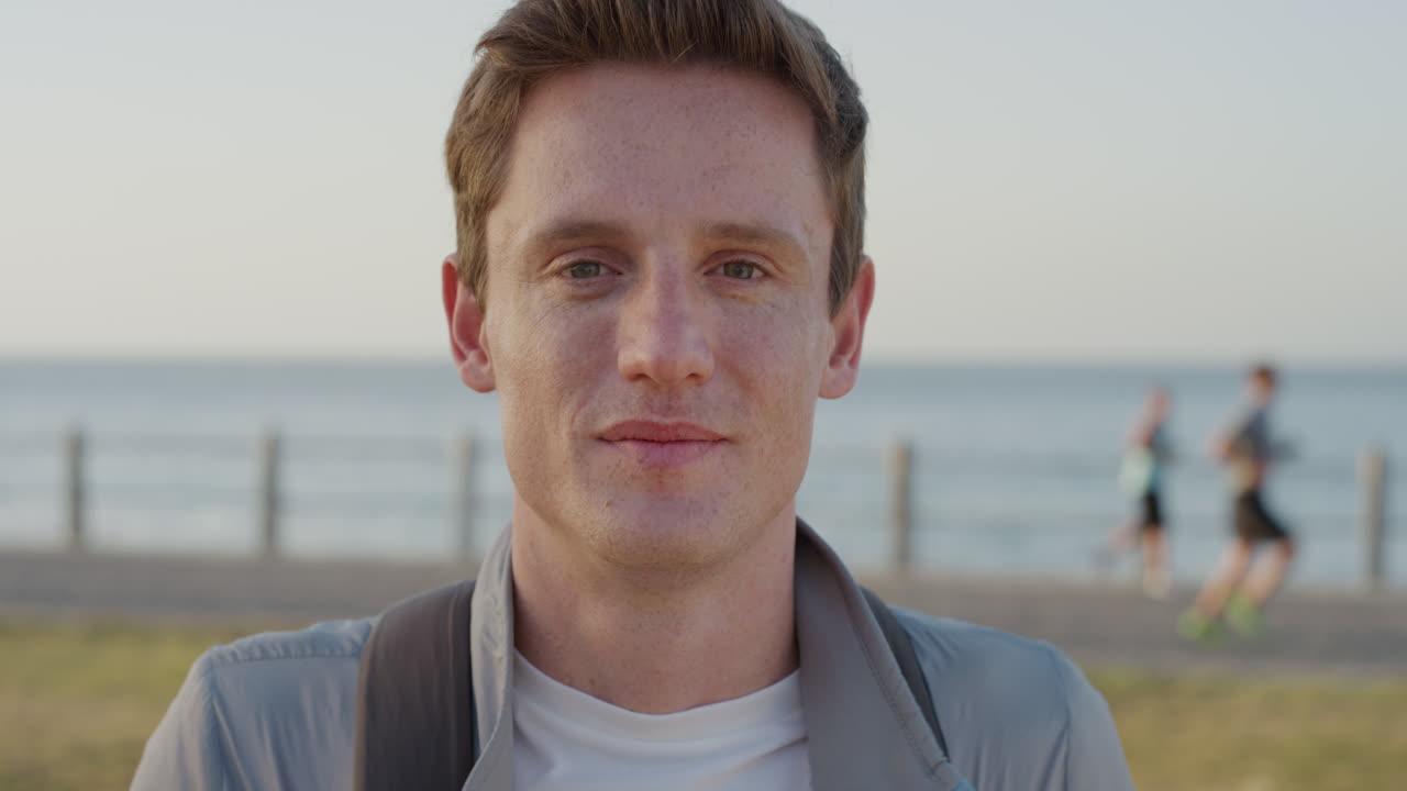 초상화 자신감 있는 젊은 남자 학생 미소 바 ⁇ 가에서 따뜻한 여름 날을 즐기고 편안한 생활 방식 느린 동작