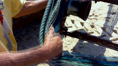 ropes and trawler fishing nets being handled by the hands of a fisherman