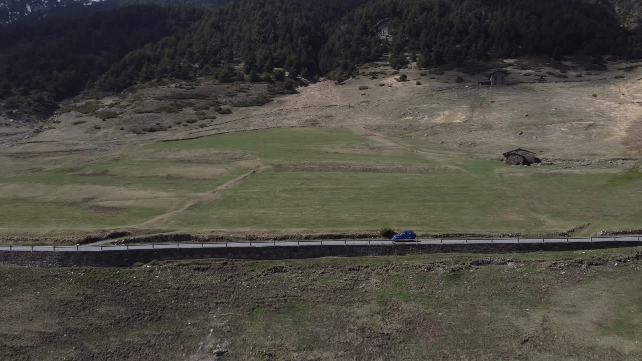 고독한 산악 도로를 따라 운전하는 고립 된 4x4 파란 차