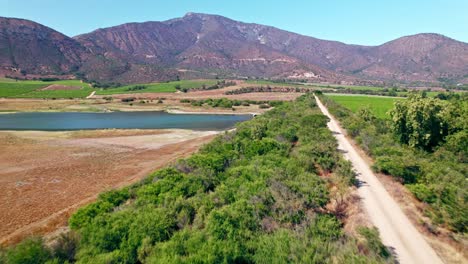 Aerial-Flyover-water-lagoon-and-Vineyards-in-Casablanca-Valley,-Chile