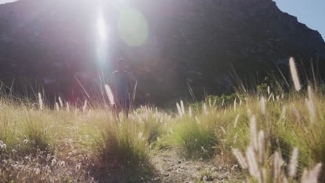 Hombre-Afroamericano-Corriendo-A-Campo-Traviesa-En-El-Campo-En-Una-Montaña