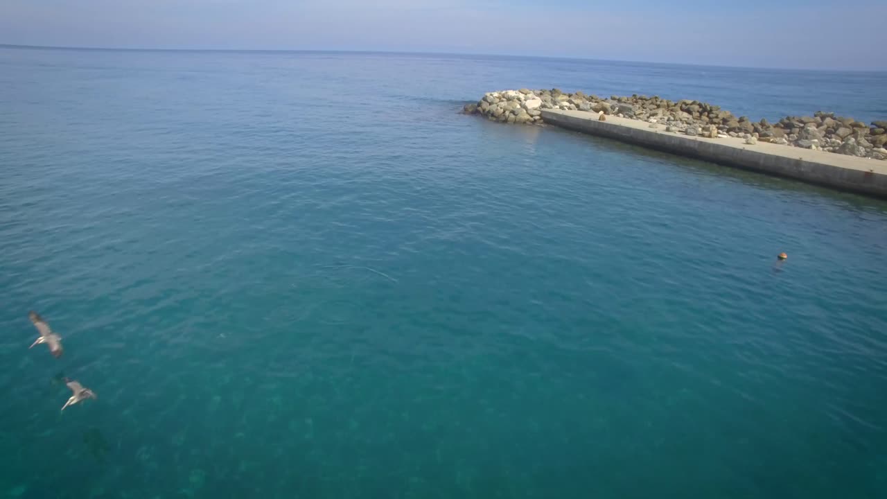 vista de drones de un rompeolas de roca en el verde y tranquilo mar caribe