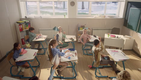 kids playing with paper planes in classroom. schoolchildren having fun