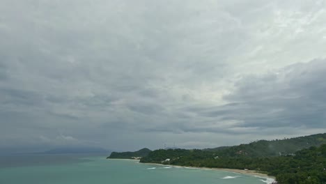 Drone-view-of-cloudy-sky,-rain-clouds-above-the-beach-Island-of-Puerto-Galera,-Philippines