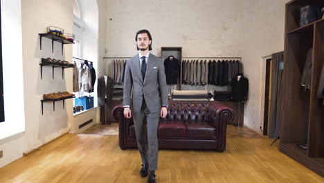 young gentleman trying on grey suit in luxurious classy boutique shop