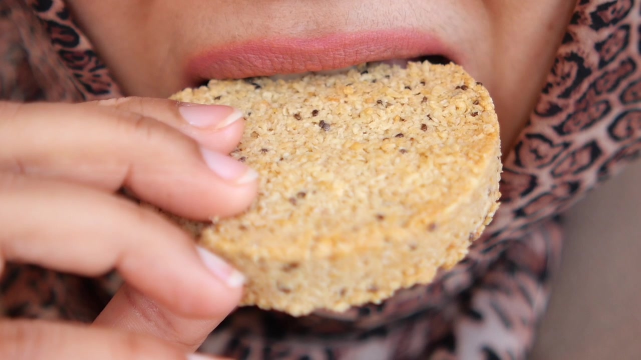 Close-up of a Woman Taking a Bite of a Sweet Cookie
