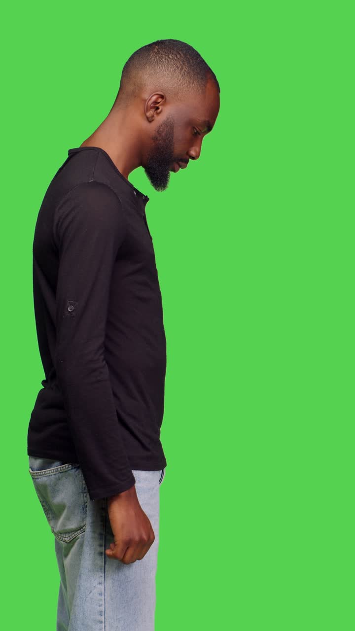 Video verticale: profilo di un giovane modello che si mette in posa davanti alla fotocamera con stile