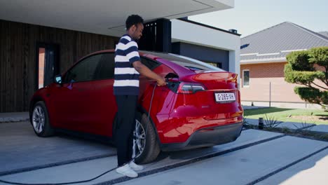 man charging an electric vehicle at home