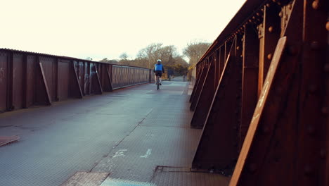 man riding bike on bridge